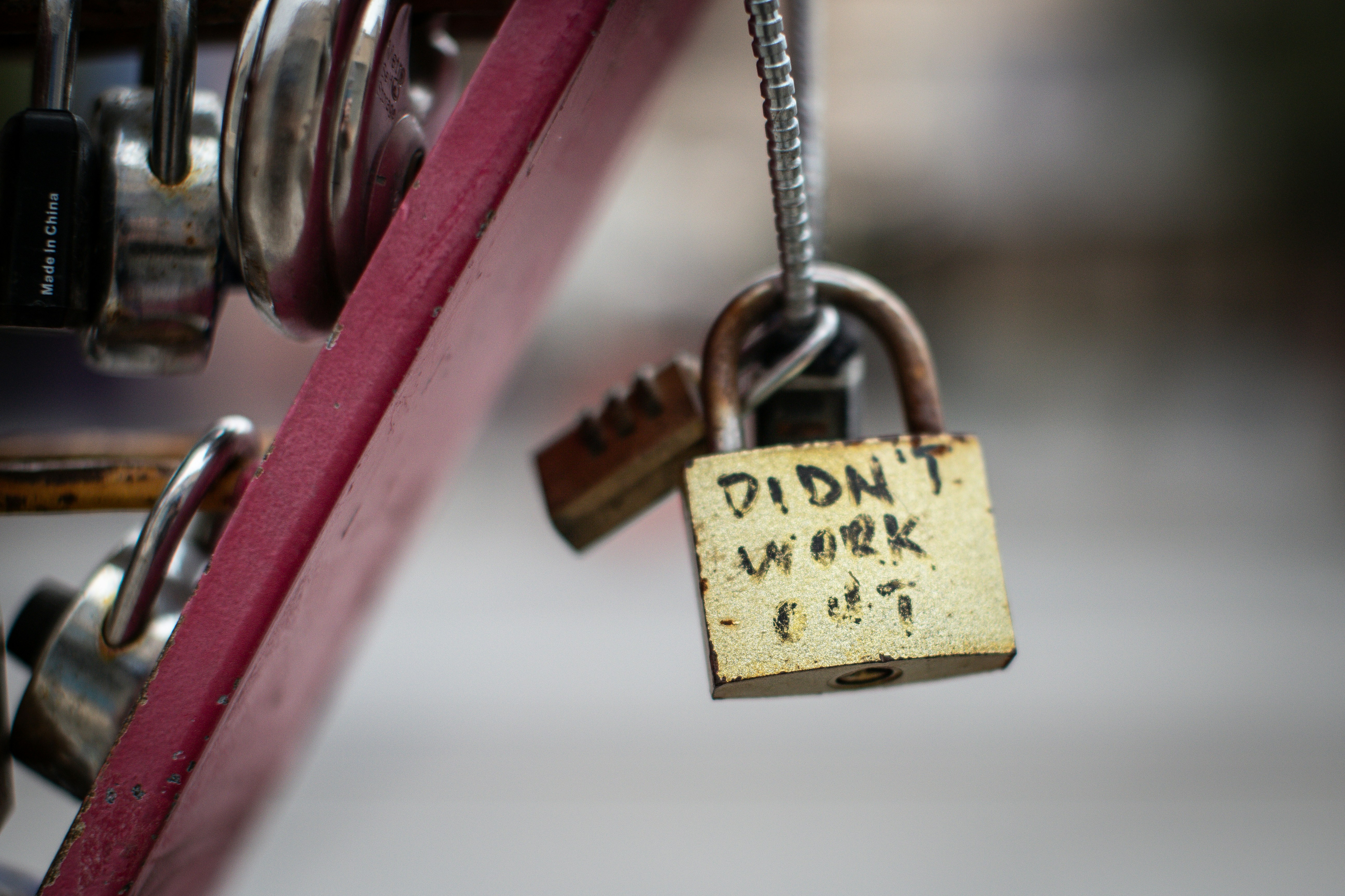 padlocks attached on a steel rod and one has a text written on it