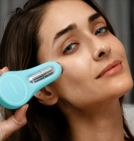 A woman using an Artic Blue Foreo BEAR 2 eyes & lips device