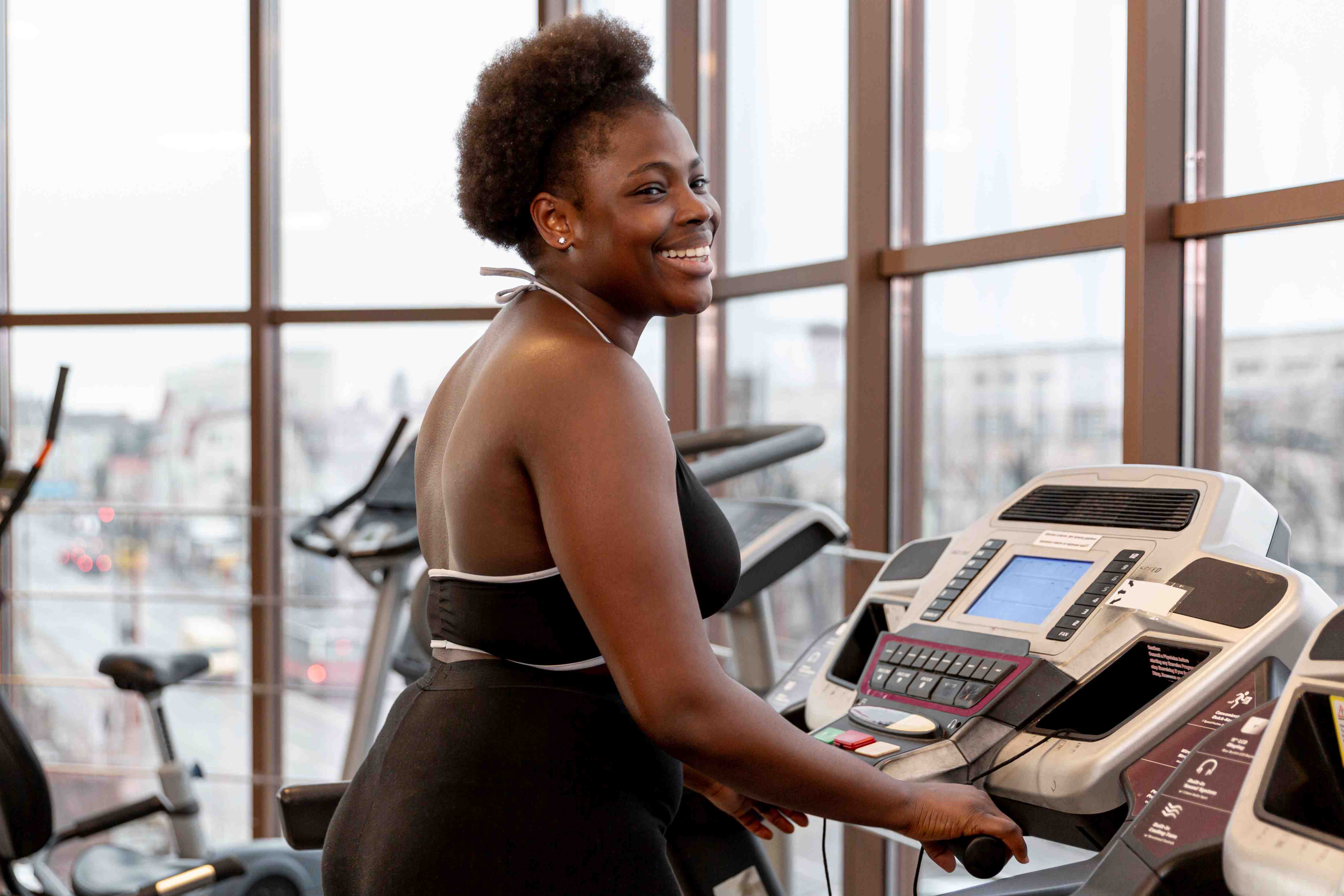 side-view-smiley-woman-working-treadmill