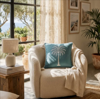 A blue palm tree cushion from the Homescapes pillow collection in a living room
