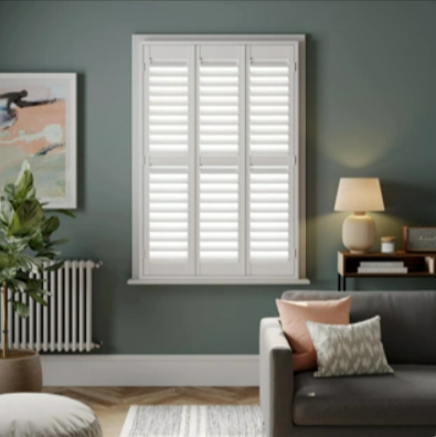 A living room with California Shutters on the windows