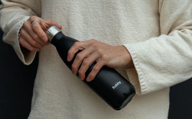 Eine Person, die eine FLSK Trinkflasche in beiden Händen hält