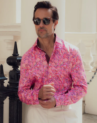 A white man wearing a pink floral Blake Mill shirt and sunglasses