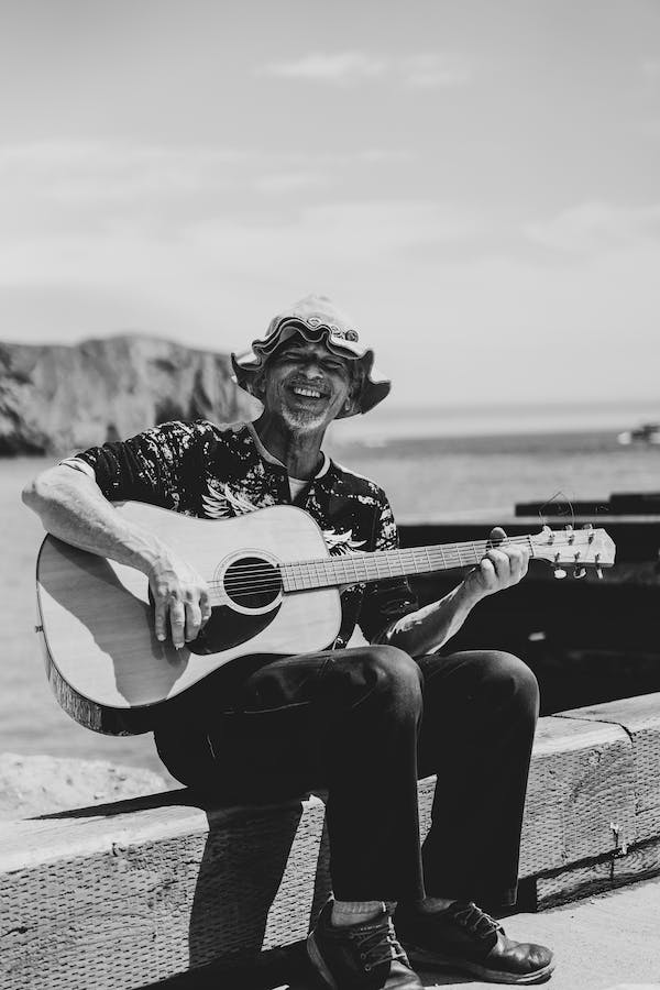 An old man with a guitar on a bridge in Spain with insurance from Medical travel insurance