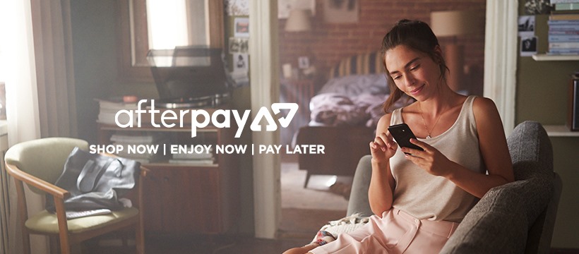 woman seated on an armchair in a living room with “Afterpay Shop Now|Enjoy Now|Pay Later”
