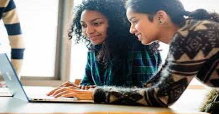 Students looking on the computer searching for Tick Travel Insurance promo code