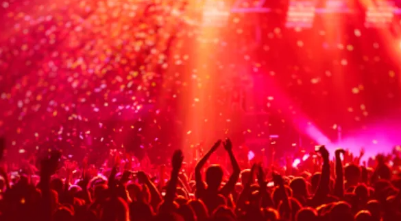 People partying with disco lights on and confetti in the air