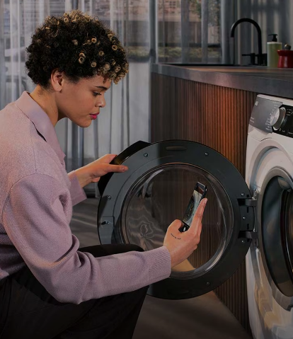 A lady taking a picture of her washing machine from AEG so that she can download the manual