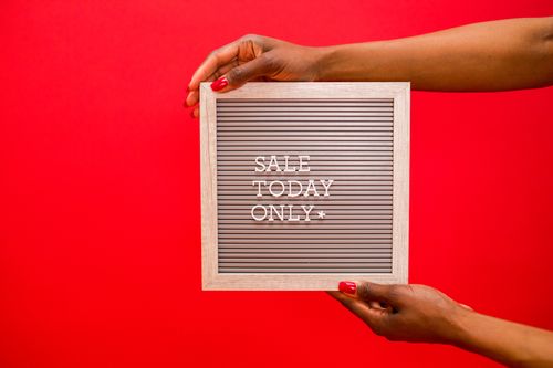 A person holding a sign saying "Sale Today Only" where you can save with Singles' Day promo codes