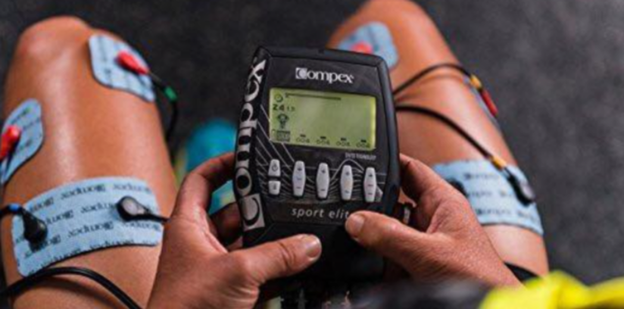 compex sport elite sujetado entre un par de manos de hombre