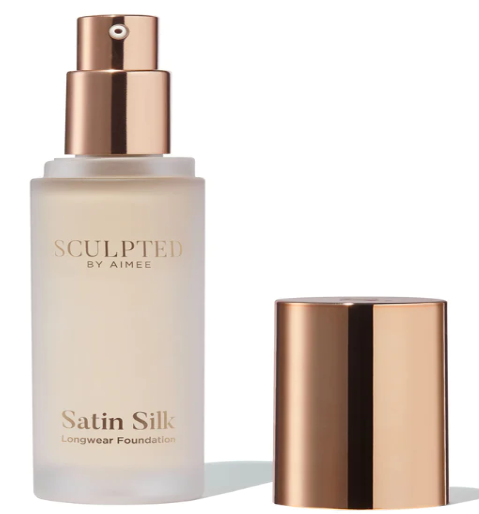 Uncapped transparent bottle with a gold top and a gold cap next to it on a white background