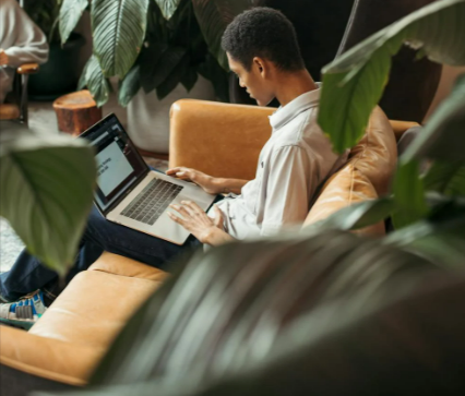 Man in white dress shirt sitting on brown chair working on his website on Create