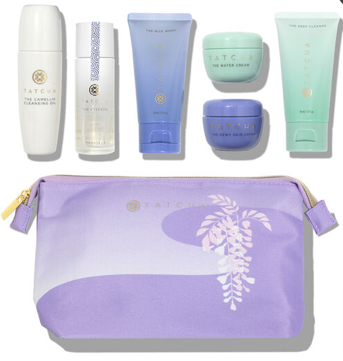 Purple mini accessory bag with a set of six Tatcha products including the camellia cleansing