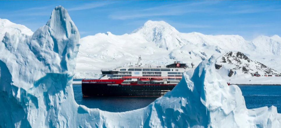Ein Kreuzfahrtschiff im Wasser von einigen Gletschern in der Antarktis umringt