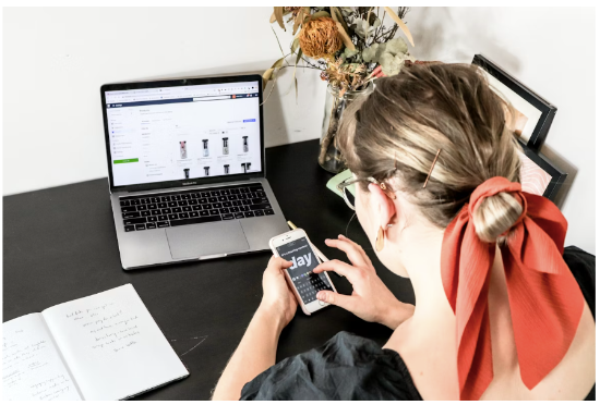 A woman is scrolling on her laptop, ready to make a purchase at AliExpress