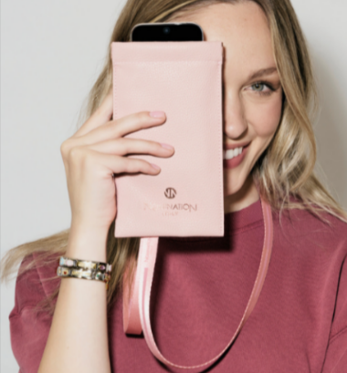 A lady holding a Nomination Italy pink pouch and wearing gold bracelets bought from Argento