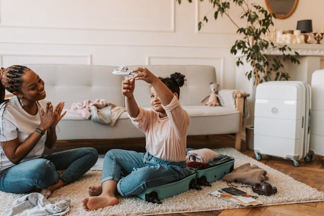 Fun school holiday activities: A woman and child playing together while packing for a trip