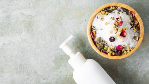 A bottle of body wash and a bowl of skincare ingredients