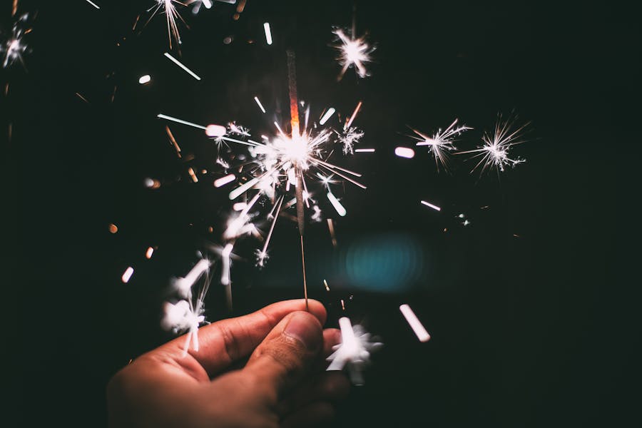 A sparkler being held by someone while it has been lit