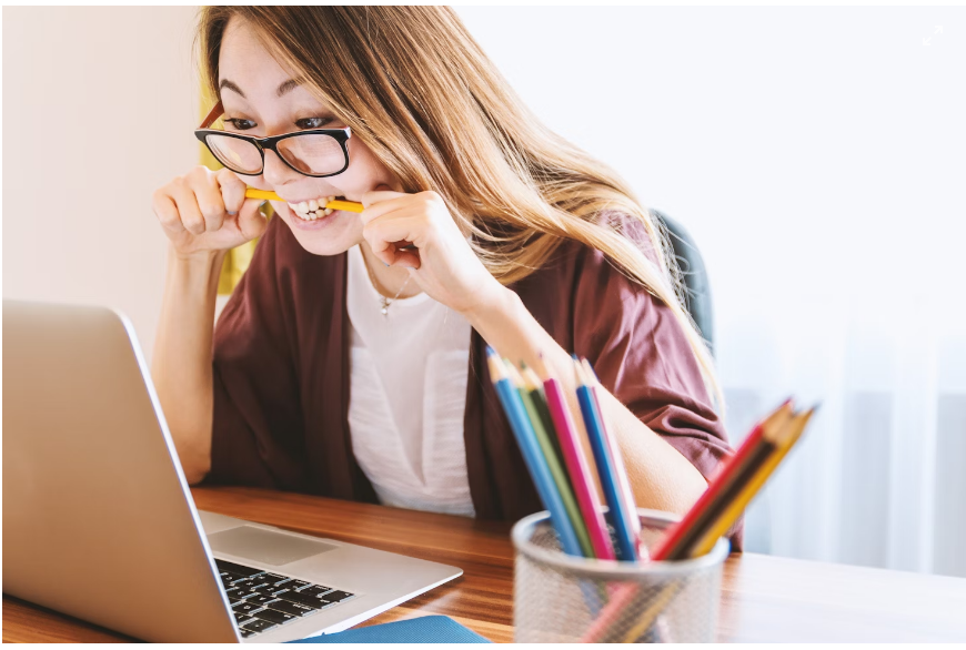A female student is excited about her Magee 1866 discount code which she applied successfully on her laptop