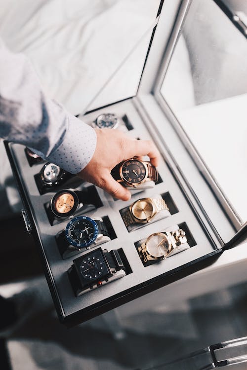 uomo che mette degli orologi Invicta in una scatola, comprati tutti a basso prezzo grazie ai coupon Invicta Stores