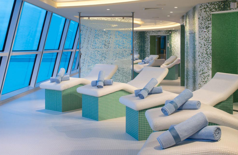 An image of the inside of a spa in a cruise ship showing arranged white towels on massage beds