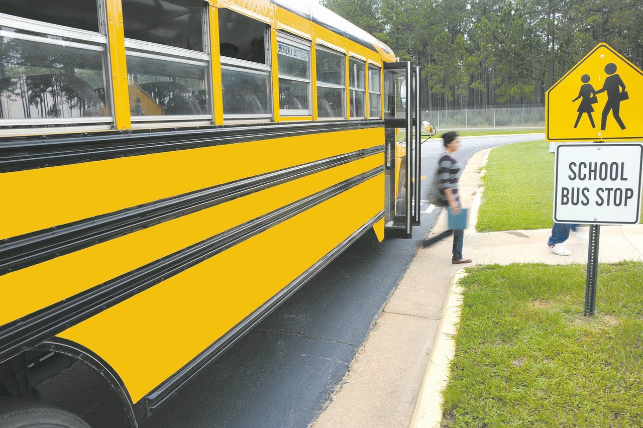 autobús de colegio amarillo parando en la escuela para los estudiantes ofreciendo ofertas de vuelta al cole