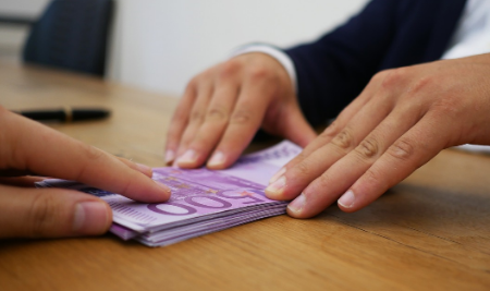 imagen de pixabay de manos entregando dinero en una mesa