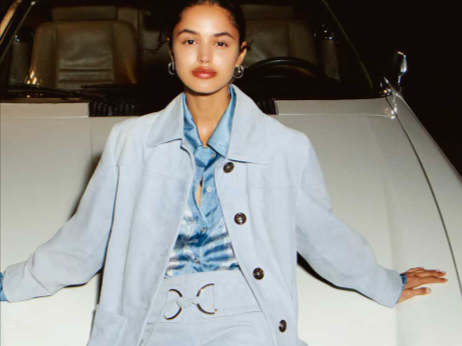 donna che indossa abbigliamento in posa su una macchina. Abito presente sullo store Liu Jo da acquistare con dei codici sconto Liu Jo