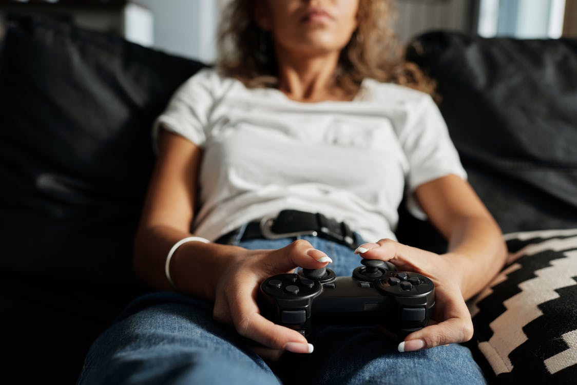donna che gioca al suo gioco digitale preferito acquistato sulla piattaforma GAMIVO grazie ad un promocode GAMIVO