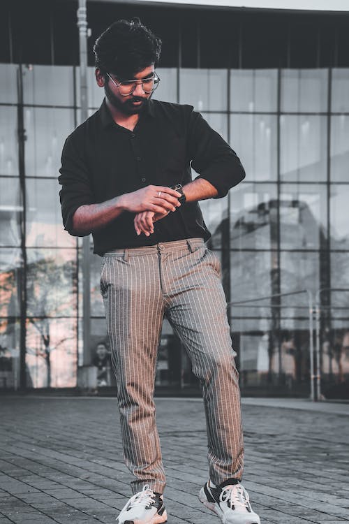 uomo che guarda il suo orologio mentre è in piedi, orologio che ha acquistato in offerta grazie ai codici sconto Invicta Stores