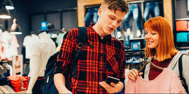 Students are browsing on the cellphone for Kimai coupon code while shopping