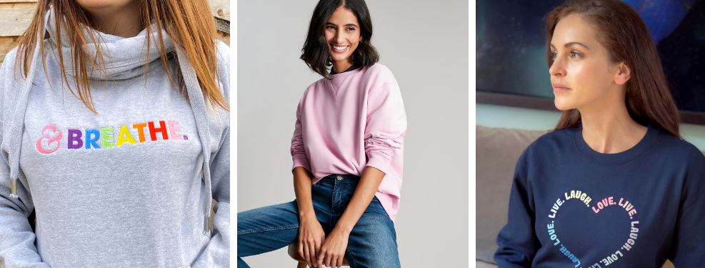 Ladies wearing crew neck sweatshirts, one is blush pink and the other have graphic designs on them