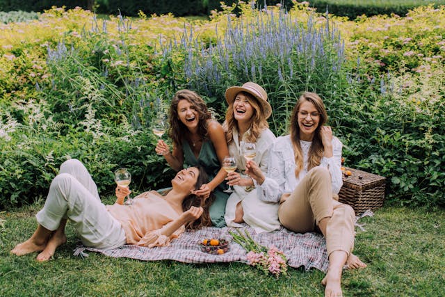 Women having a picnic together to celebrate International Women's Day 2024 with things they brought from Love Coupons