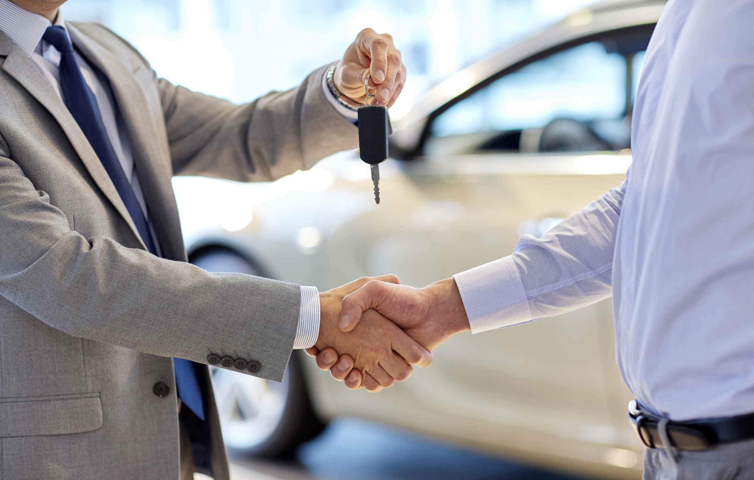 Otomobil promosyon kodu ile sahibinden ikinci el araba satın alan genç adam galeri sahibinden arabanın anahtarını alıyor