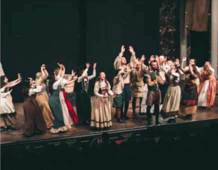People performing on a theatre stage in a show with tickets available at Eventim
