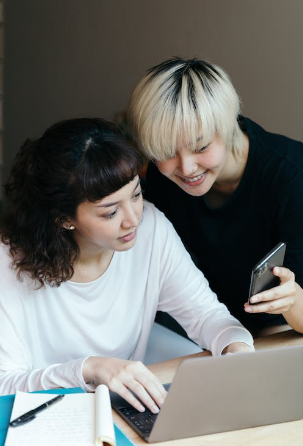 Friends one in a white long sleeve and the other in black searching for a Razer education discount