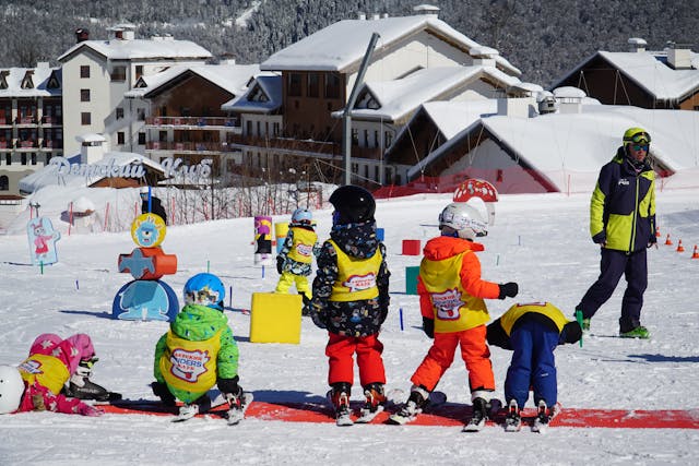 July school holidays: A group of children skiing on a snow-covered slope