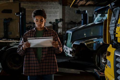 A person reading a Haynes manual that they saved on with a coupon code from Love Discount Vouchers
