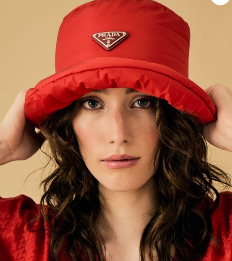 A lady wearing a red Prada hat form Consigned Sealed Delivered