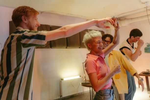 A group of happy people dancing together in a room celebrating Singles Day