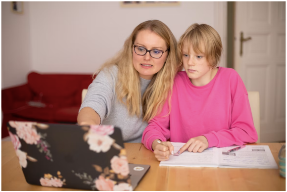 A parent seated with her child, checking on her progress at Estia Tuition
