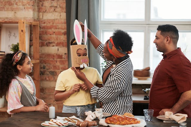 Things to do over Easter: A child wearing an Easter bunny mask around her family
