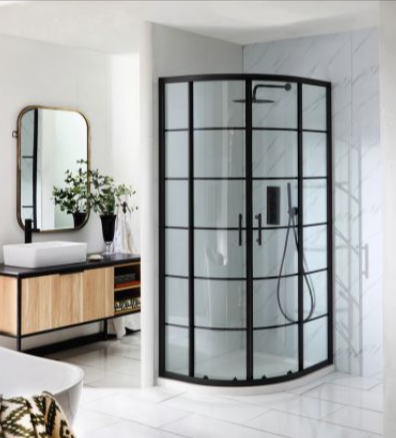 A modern bathroom with a black framed and curved glass shower and a wooden vanity with a sink