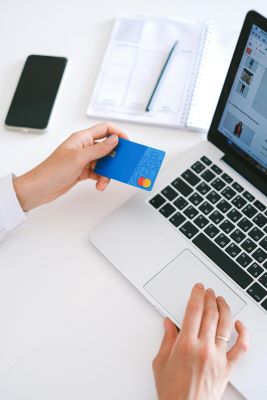 Hands scrolling on a laptop with a credit card, ready to use a Cyber Weekend voucher code