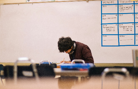 a boy living in the Uk at his school working on a class work