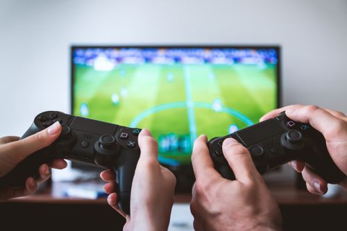 Two people playing a game from Game that they saved on with a Game discount code