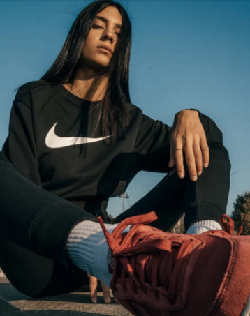 A lady wearing a Nike sweatshirt bought from Footshop
