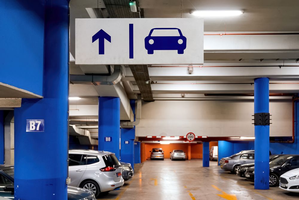 A2Z Airport Parking full-car-parking-lot-underground with arrows showing a car where to park behind blue pillars