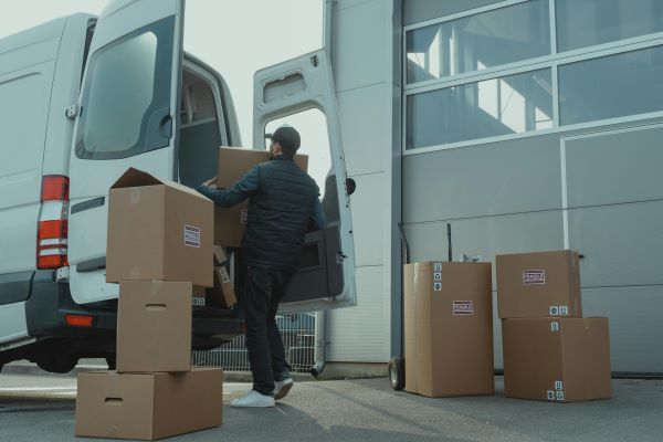 A man carrying boxes into an open white van
